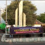 Gelar Spanduk di Pertigaan Jalan Raya “Tugu Bambu Runcing” Mojoagung Jombang.